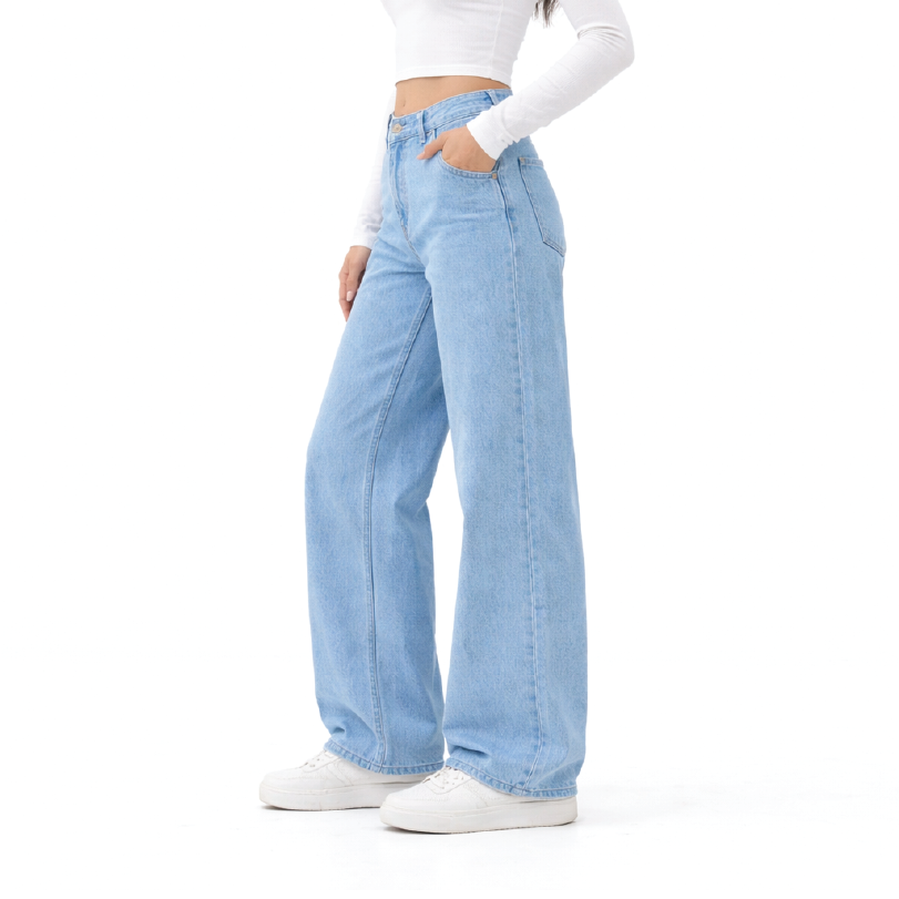 A model wearing light wash blue wide-leg jeans, a white long-sleeve crop top, and white sneakers, shown from the waist down against a solid white background.