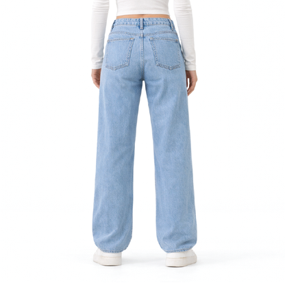 A person shown from the back wearing light-wash wide-leg denim jeans, a white long-sleeve crop top, and white sneakers against a plain white studio background.